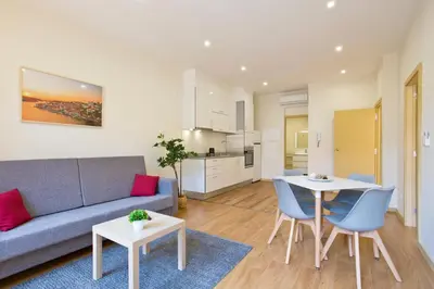 a living room with a couch and a table and chairs at Aposentus - CS Trindade Apartments in Porto