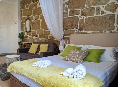 a bedroom with a bed with towels on it at Porto-Stone Wall Apartment in Porto