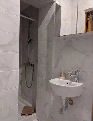 a white bathroom with a sink and a shower at Porto-Stone Wall Apartment in Porto