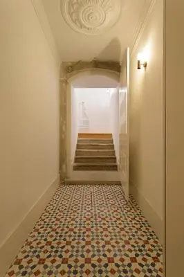 an empty hallway with a tile floor and stairs at APOSENTUS - Your home in Almada in Porto