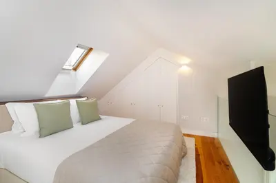 a bedroom with a bed and a flat screen tv at WHome Trendy Cedofeita Loft - Luxe & Light-Filled in Porto