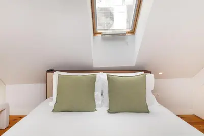 a bedroom with a bed with two pillows and a window at WHome Trendy Cedofeita Loft - Luxe & Light-Filled in Porto
