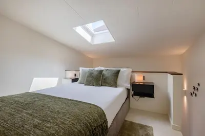 a bedroom with a white bed and a skylight at Urban Loft @ Terracotta Collection in Porto