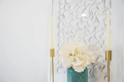 a green vase with two white flowers and two candles at GuestReady - Urkunina apartment in Porto