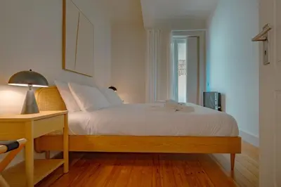 a bedroom with a bed and a table with a lamp at The Cale - Porto, Firmeza 2 in Porto