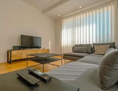 a living room with two remote controls on a couch at The Cale - Porto, Firmeza 2 in Porto