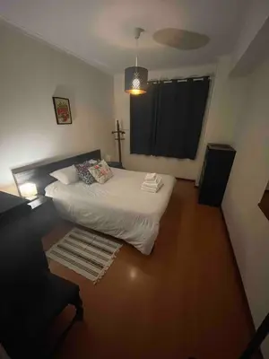 a bedroom with a bed and a cross on the window at T1 near El Corte Inglés in Vila Nova de Gaia