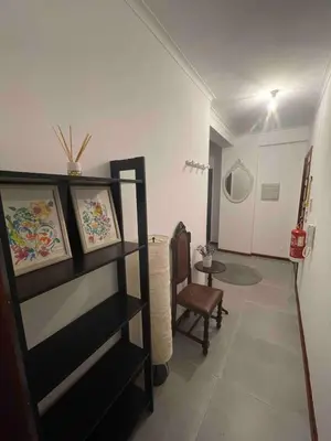 a room with a shelf and a chair and a table at T1 near El Corte Inglés in Vila Nova de Gaia