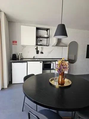 a kitchen with a table with a vase of flowers on it at Lima Junior Residences in Porto