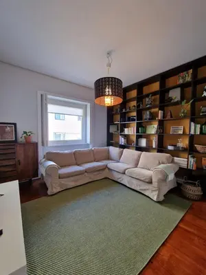 a living room with a couch and book shelves at Lima Junior Residences in Porto
