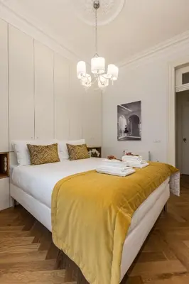 a bedroom with a large bed with a yellow blanket on it at Bailarina Historic Luxury House at Rua das Flores in Porto