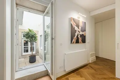 a hallway with a large glass door and a potted plant at Bailarina Historic Luxury House at Rua das Flores in Porto