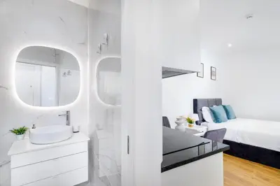 a white bathroom with a sink and a bed at Cozy Studio 2 min walk to Douro River with AC in Vila Nova de Gaia