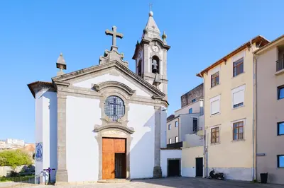 a church with a clock tower in a city at Cozy Studio 2 min walk to Douro River with AC in Vila Nova de Gaia