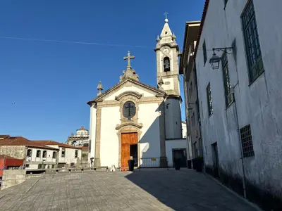 a church with a steeple and a clock tower at Cozy Studio 2 min walk to Douro River with AC in Vila Nova de Gaia