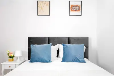 a bedroom with a bed with blue pillows at Cozy Studio 2 min walk to Douro River with AC in Vila Nova de Gaia