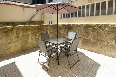 a table with two chairs and an umbrella at Sunny House with Patio, Walk to Attractions in Vila Nova de Gaia