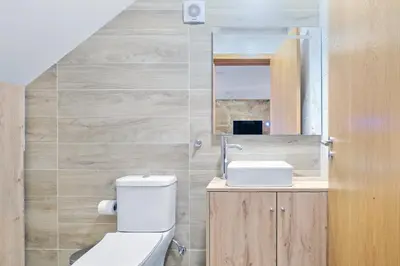 a bathroom with a toilet and a sink and a mirror at Sunny House with Patio, Walk to Attractions in Vila Nova de Gaia