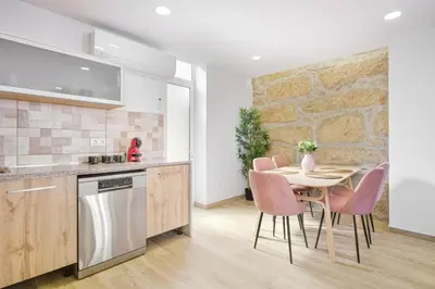 a kitchen with a table and pink chairs in a kitchen at Sunny House with Patio, Walk to Attractions in Vila Nova de Gaia