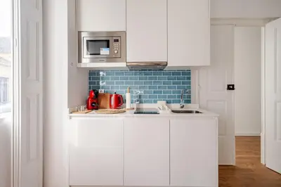 a kitchen with white cabinets and a microwave at 2-Studio House Steps from Best Attractions of Porto in Vila Nova de Gaia
