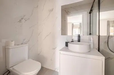 a white bathroom with a toilet and a sink at 2-Studio House Steps from Best Attractions of Porto in Vila Nova de Gaia