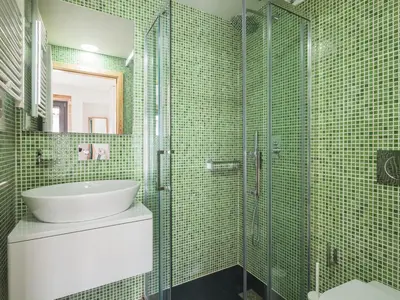 a green tiled bathroom with a sink and a shower at Trindade by Guestify in Porto
