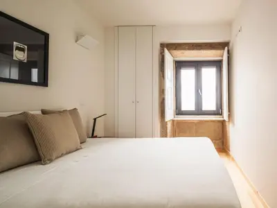 a bedroom with a large white bed with a window at Trindade by Guestify in Porto