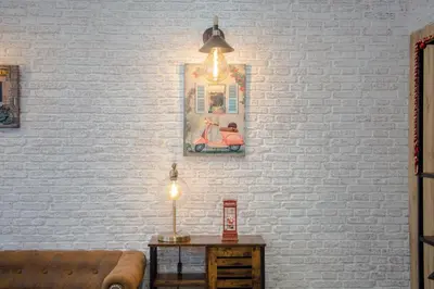 a living room with a brick wall and a table with a lamp at Magnolia Suites & Stays in Porto