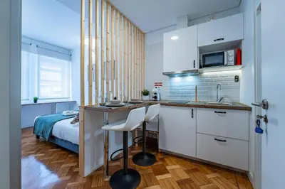 a kitchen with white cabinets and a bed in a room at New Alegria in Town 2 in Porto