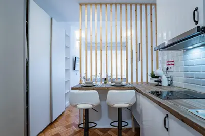 a kitchen with two white stools at a counter at New Alegria in Town 2 in Porto