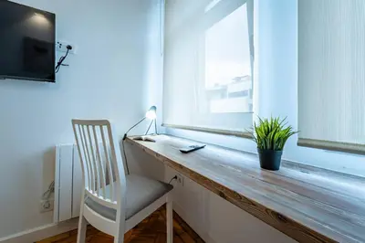 a desk in a room with a chair and a window at New Alegria in Town 2 in Porto