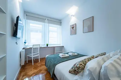 a white bedroom with a bed and a desk at New Alegria in Town 2 in Porto