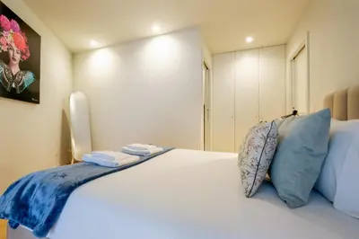 a bedroom with a large white bed with blue pillows at Luxury Style 6 with AC Downtown Porto near Metro in Porto