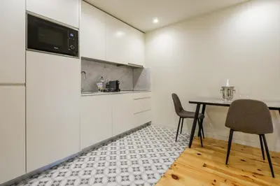 a kitchen with a table with two chairs and a microwave at Luxury Style 6 with AC Downtown Porto near Metro in Porto