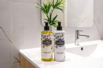 two bottles of soap sitting on a bathroom sink at Luxury Style 6 with AC Downtown Porto near Metro in Porto