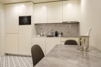 a kitchen with white cabinets and a table with chairs at Luxury Style 6 with AC Downtown Porto near Metro in Porto