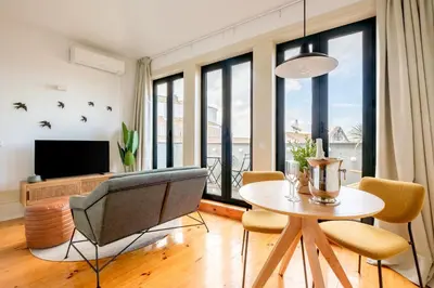 a living room with a table and chairs and a television at Cedofeita Sunshine Luxury Apartment Downtown Porto in Porto