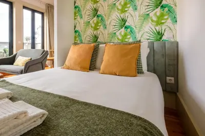 a bedroom with a large bed with yellow pillows at Cedofeita Sunshine Luxury Apartment Downtown Porto in Porto