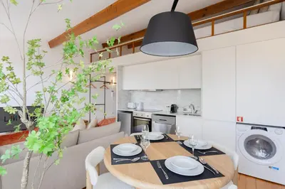 a kitchen and living room with a wooden table and a dining room at Liiiving in Porto - Mezzanine Delight Balcony in Porto