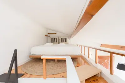 a bedroom with a bed and a desk in a attic at Liiiving in Porto - Mezzanine Delight Balcony in Porto