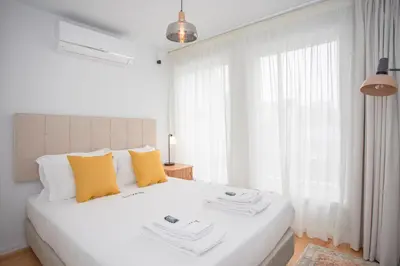a white bedroom with a large white bed with yellow pillows at Liiiving in Porto - Modern & Glam Apartment J in Porto