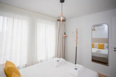 a white room with a bed and a mirror at Liiiving in Porto - Modern & Glam Apartment J in Porto