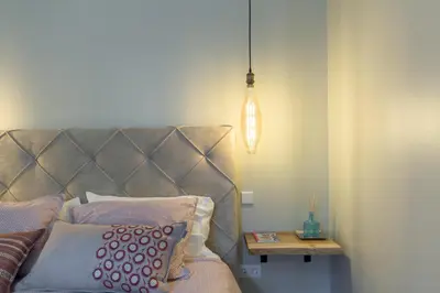 a bed with a headboard and a table with a lamp at Stylish Downtown Porto Duplex 2BR Walk everywhere! in Porto