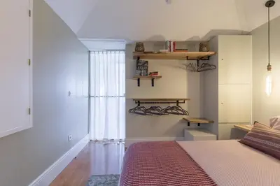 a bedroom with a bed with a red comforter at Stylish Downtown Porto Duplex 2BR Walk everywhere! in Porto