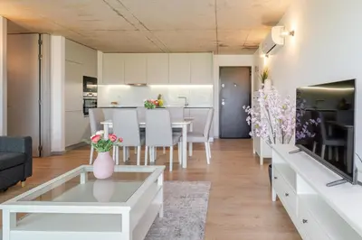 a living room with a table and a dining room at HostWise - Modern Flat w/ Balcony, Garage & Pool in Vila Nova de Gaia
