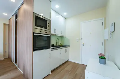 a kitchen with white cabinets and a tv above the oven at Close to Everything Your Oporto Blue PRM 2F in Porto