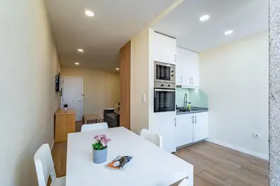 a kitchen and dining room with a white table and chairs at Close to Everything Your Oporto Gray PRM 2T in Porto