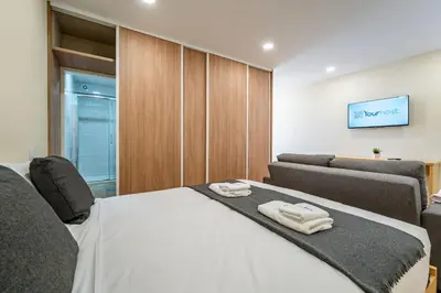 a bedroom with a bed and a couch at Close to Everything Your Oporto Gray PRM 2T in Porto