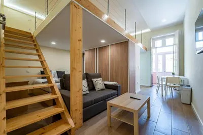 a living room with a couch and a staircase at Close to Everything Your Oporto Terrace PRM 1T in Porto