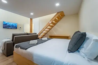 a bedroom with a large bed and a staircase at Close to Everything Your Oporto Terrace PRM 1T in Porto
